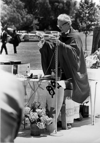 (3316) A priest prepares communion during an open-air mass (3316) A priest prepares communion during an open-air mass